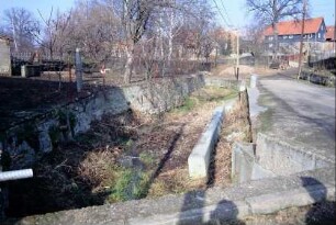 Wasserlauf, teilweise Natursteinböschungsmauer, teilweise Beton; Gebäude