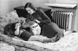 Bukarest: Haus des + Schriftleiters Wilhelm Müller, Frau Müller mit Junge und Hund auf Sofa, liegend