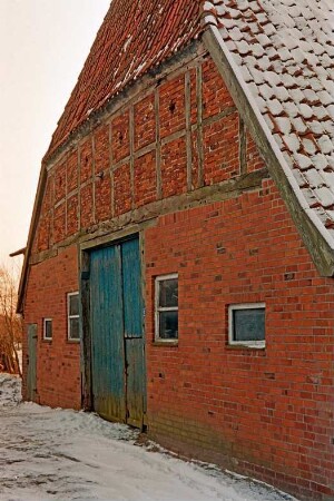 Fischbek: Am Dorfplatz (10): giebelständiges Fachwerkhaus mit Feldsteinfundament: Giebelseite Wirtschaftstrakt mit Scheunentor