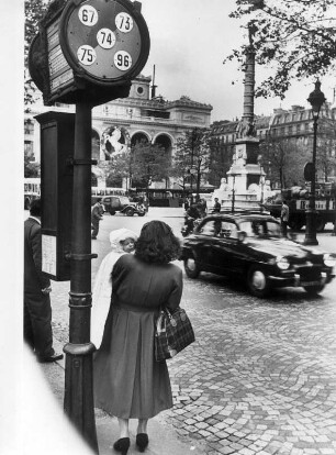 Frankreich. Paris. Eine Frau steht an einer Haltestelle.