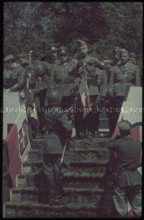 Italienische und deutsche Soldaten auf einer Tribüne