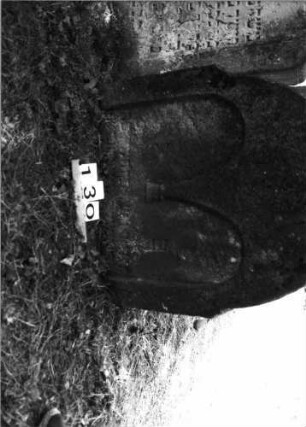 Grabstein 130 (Index: 100085486) Zustand: Stein eingesunken Maße HxBxT: 75x70x18 cm Beschreibung: Stele, Rundbogenabschl. , Schriftfeld eingetieft m. 2-bogig. Rundbogenabschl. /Maßwerk: Grabstein 130