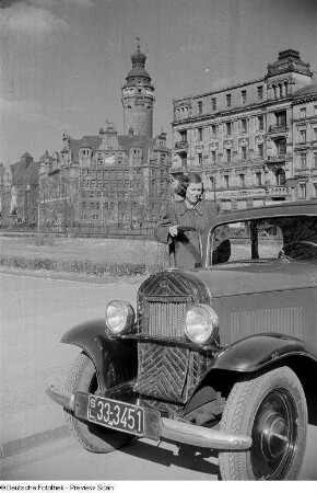 Porträt von Renate Rössing an einem Auto, im Hintergrund das Neue Rathaus