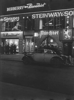Berlin, Geschäftshaus mit Läden und Werbung der Firmen "Burberry Mäntel Benedickt", "Steinway & Sons", "Münchner". Nachtaufnahme