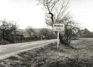 Altdöbern-Reddern, Hauptstraße. Ortseingang mit Ortsschild. Blick zur Fachwerkscheune nach Nordosten