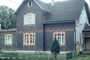 Haus mit Zwerchgiebel, schönen Fenstern, Windfang, kleiner Vorgarten