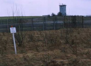 Deutsch-deutsche Grenze : Wachturm hinter der deutsch-deutschen Grenze. Im Vordergrund ein Schild "Halt! Hier Grenze", im Kreis Duderstadt.