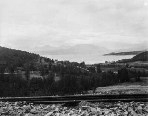 Talblick : Blick von einer Anhöhe über Eisenbahnschienen in ein Tal mit Fjord.