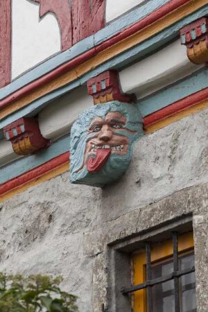 Balkenkopf mit geschnitzter Fratze