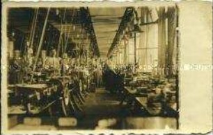 Arbeiter und Arbeiterinnen in einer Maschinenhalle