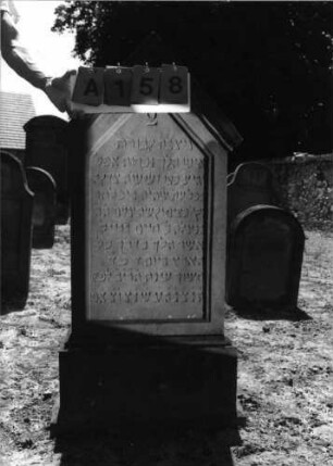 Grabstein 158 (Index: 99798020) Material: Sandstein, rot Zustand: gut Maße HxBxT: 128x62x18 cm Beschreibung: Stele, giebelartiger Abschluß mit Verdachung, getreppter Sockel: Grabstein 158A