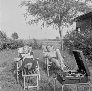 Paar in Liegestühlen im Garten mit Koffergrammophon