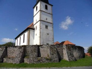 Ansicht von Ostsüdosten mit Kirche über Kirchhofmauer (Wehrgang mit Brüstung und Schießscharten abgetragen) - Strebepfeiler zur Feldseite