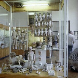 Sonneberg. Deutsches Spielezeugmuseum. Vitrine mit Puppen in unterschiedlichen Stadien der Produktion und Werkzeugen zur Anfertigung von Puppen