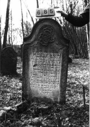 Grabstein 685 (Index: 99752391) Material: Sandstein Zustand: leicht verwittert Maße HxBxT: 125x62x10 cm Beschreibung: Stele, Konvexbogenabschluß Symbolik: Blüten, geometrisches Fries, Voluten: Grabstein 685