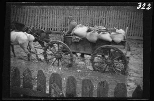 Wirballen (=Virbalis, Litauen): Zweispänner mit beladenem Pferdewagen auf einem tief morastigen Ortsweg ("Straße in Wirballen")