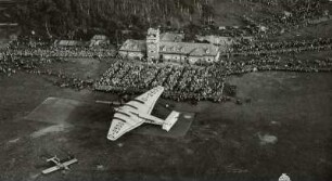 Flugplatz Dresden-Heller, Verkehrsflugzeug Junkers G 38 am Flugtag auf dem Rollfeld mit Zuschauern vor dem Abfertigungsgebäude mit Kontrollturm, Luftbild-Schrägaufnahme