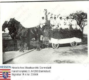Nieder-Wöllstadt, 1934 Mai 1 (?) / Umzug der Metzger von Nieder-Wöllstadt, auf mit kleinen Wimpeln mit Hakenkreuzen geschmücktem Pferdewagen / Gruppenaufnahme
