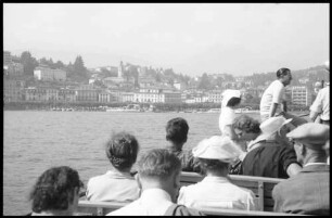 Lugano: Stadt vom See mit Motorbootgästen im Vordergrund