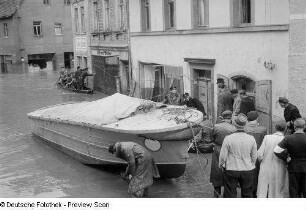 Menschenansammlung in einer überschwemmten Straße
