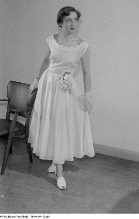 Eine Frau posiert mit Festkleidung bei der "Internationalen Messemodenschau", Herbstmesse 1953