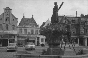 Husum: Brunnendenkmal [Tine-Brunnen] auf dem Marktplatz, mit Geburtshaus von Theodor Storm