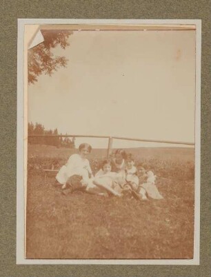 Raimund, Christiane und Franz von Hofmannsthal sitzen mit zwei Frauen und einem Mädchen an einem Holzgeländer in Aussee
