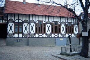 Gemeindehaus und Platz mit Pumpe und Baum