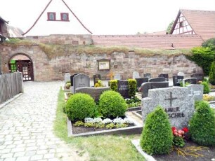 Kirchhof im Westen mit Kirchhofmauer und Torbogen