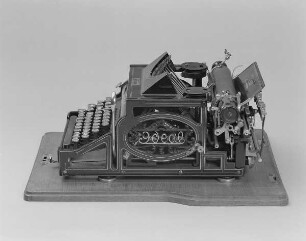 Typenhebelschreibmaschine "Ideal" (Modell A 3). Erste deutsche Typenhebelschreibmaschine mit Vorderanschlag (sofort sichtbare Schrift), 42 Tasten, Farbband. Seitenansicht von rechts oben