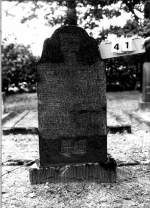 Grabstein 41 (Index: 100110142) Material: Granit Zustand: gut Maße HxBxT: 126x55x18 cm Beschreibung: Stele, Sockel, geschwungener Rundbogenabschluß Symbolik: Davidstern Besonderheit: Doppelgrab für Eheleute: Grabstein 41