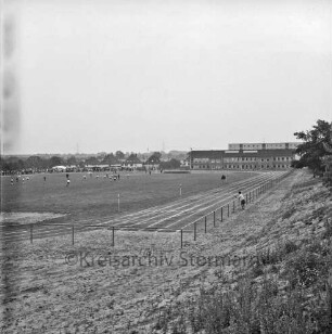 Teichweg: Sportanlage: Einweihung: ein Fußballspiel findet statt, rechts die Laufbahn, im Hintergrund die Grundschule Hoisbüttel