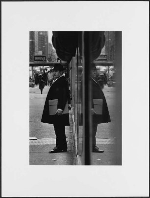 Mann mit Hut und Mappe unter dem Arm auf einer Straße, New York