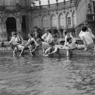 Dresden-Altstadt. Lehrerin (oder Pionierleiterin) mit einer Gruppe Junger Pioniere am Rand eines Brunnenbeckens im Zwingerhof
