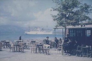 Reisefotos Griechenland. Strandcafé und vor der Küste ankerndes Passagierschiff "Milwaukee" (vielleicht im Mittelmeer)