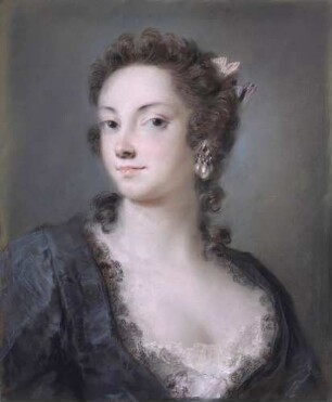 Eine Dame in schwarzem Spitzenkleid und rosa Schleife