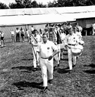 Kindervogelschießen: Festwiese: Festumzug: vorn Spielmannszug des Ahrensburger Turn- und Sportvereins (TSV) von 1874 e. V.: dahinter Kapelle der Freiwilligen Feuerwehr Großhansdorf: hinten Zuschauer vor Festzelt
