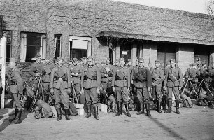 Zweiter Weltkrieg. Niederlande unter deutscher Besatzung. Angehörige der deutschen Wehrmacht mit Marschgepäck vor einem Gebäude (wohl bei Den Haag)