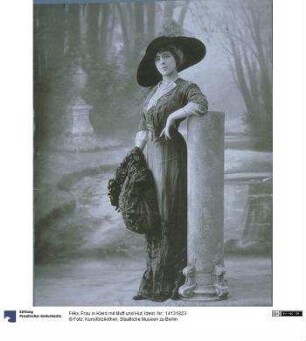 Frau in Kleid mit Muff und Hut