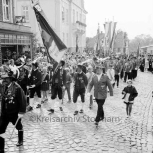 Schützenfest: Veranstalter Schützenverein Reinfeld und Umgebung von 1954 e.V.: Umzug: Paul-von-Schoenaich-Straße: Vorsitzender Hans-Georg Talies: Tiroler Schützen der Schützenkompanie Wilten (bei Innsbruck) mit Fahne, voran Hauptmann Karl Sagstetter: dahinter Schützenvereine mit Fahnen: an den Straßenrändern Zuschauer: Bildmitte hinten Rathaus, davor Fahnenschmuck, 8. September 1963