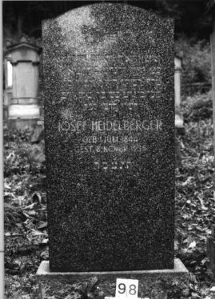 Grabstein 98 (Index: 100080013) Material: Granit Zustand: gut Maße HxBxT: 151x71x17 cm Beschreibung: Stele, Sockel, eingezogener Segmentbogenabschluß: Grabstein 98