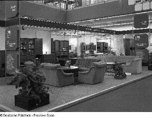 Raumaufnahme mit Ausstellungskojen des VEB Möbelkombinat Zeulenroda-Triebes (ZEUTRIE). Ansicht mit Sitzgruppen