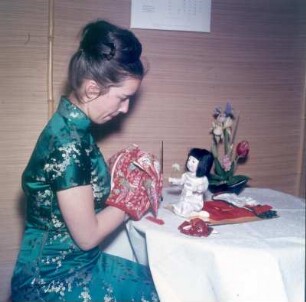 Japan. Puppenherstellerin beim Ankleiden einer Puppe
