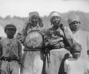 Kingston (Jamaika). Gruppenbildnis afroamerikanischer Frauen (Pfeife rauchend) und Kinder