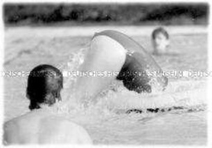 Mädchen springt in einen Schwimmreifen (Altersgruppe 18-21)