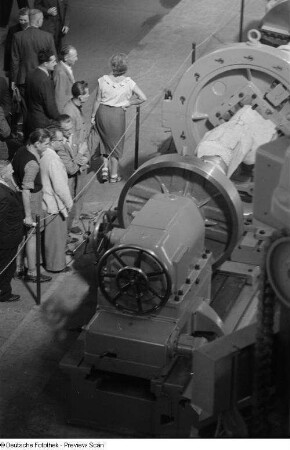 Besucher der Technischen Messe 1953 betrachten eine Werkzeugmaschine