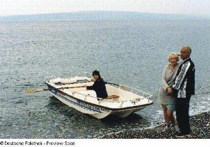 Frau in einem Boot und Paar am Strand