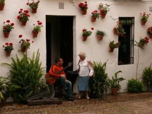 Musiker, Touristen in einer blumengeschmückten Altstadtgasse