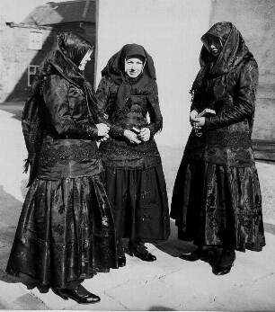Wittichenau (Oberlausitz). Katholische Mädchen stehen in dunkler Festtagstracht vor der Kirche