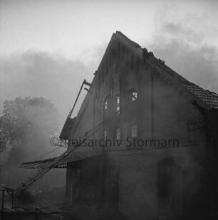 Gut Altfresenburg: Brand des Bullenstalls: Brandruine: Giebelfront mit Förderband: hinten Rauchschwaden und Bäume: 24. August 1971